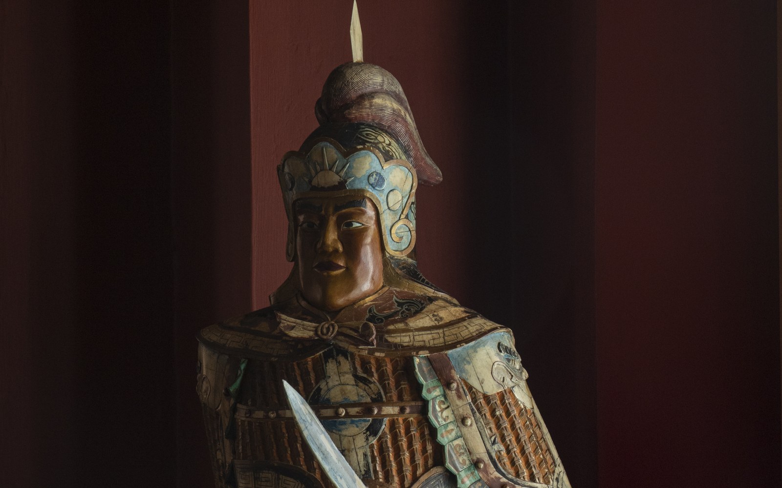 Oriental carving of a warrior in polychrome armour holding a sabre, from the Casa de los Leones collection